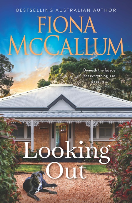 The cover of a book by Fiona McCallum titled Looking Out, showing blue sky and green trees above the corrugated metal roof of a traditional stone house which has an open front door. Outside on a pale brown path lies a black dog with white chest. 